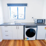 the goldminer accessible studio apartment kitchenette and laundry